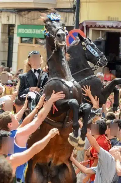 fiestas de Menorca en el jaleo donde aparece chica subida a un caballo realizando bailes y cabriolas rodeada de gente