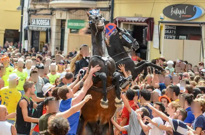 fiestas de Menorca en el jaleo donde aparece chica subida a un caballo realizando bailes y cabriolas rodeada de gente