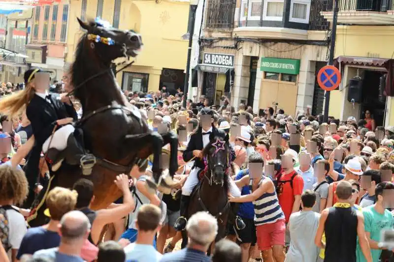 fiestas de Menorca en el jaleo donde aparece chica subida a un caballo realizando bailes y cabriolas rodeada de gente
