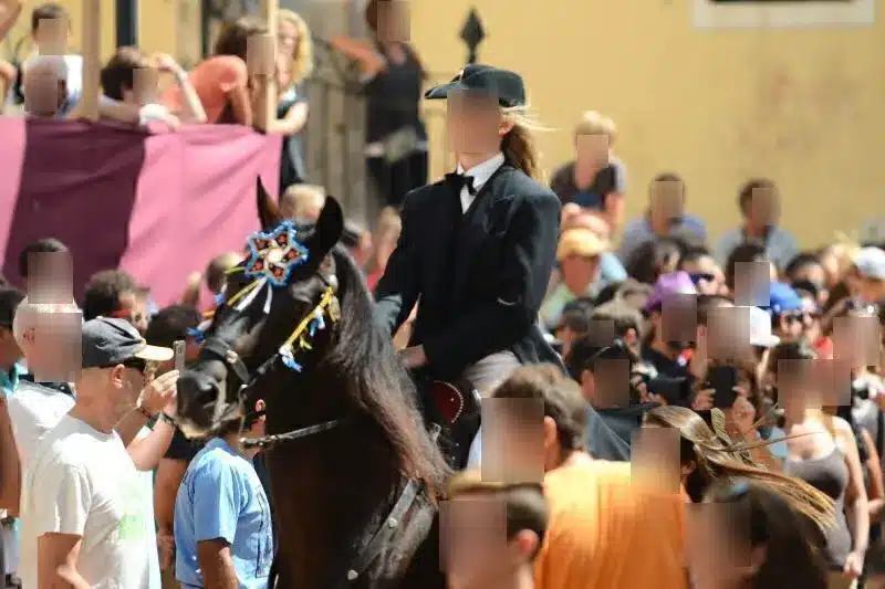 fiestas de Menorca en el jaleo donde aparece chica subida a un caballo realizando bailes y cabriolas rodeada de gente