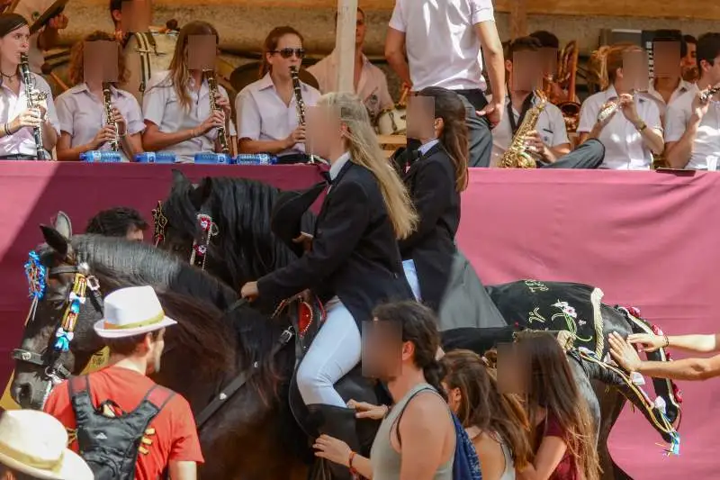 fiestas de Menorca en el jaleo donde aparece chica subida a un caballo realizando bailes y cabriolas rodeada de gente