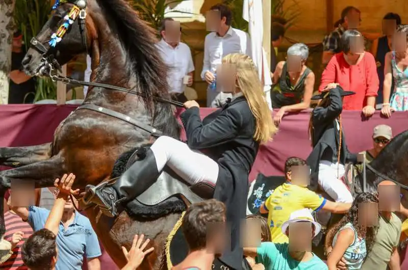 fiestas de Menorca en el jaleo donde aparece chica subida a un caballo realizando bailes y cabriolas rodeada de gente