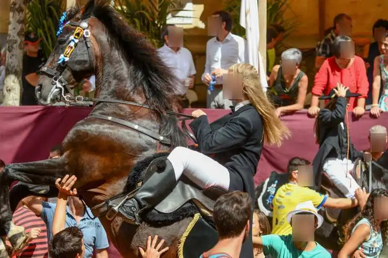 fiestas de Menorca en el jaleo donde aparece chica subida a un caballo realizando bailes y cabriolas rodeada de gente