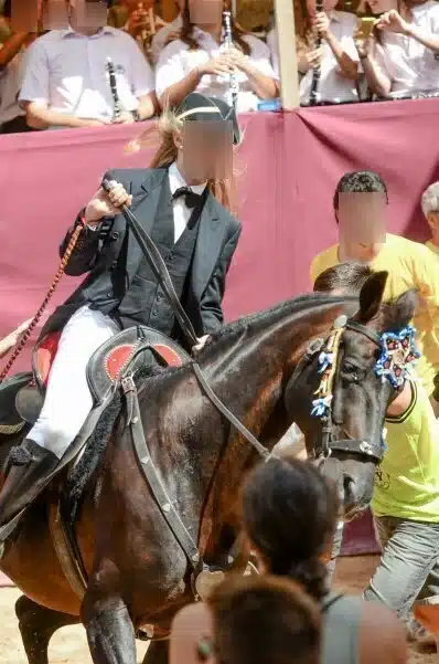 fiestas de Menorca en el jaleo donde aparece chica subida a un caballo realizando bailes y cabriolas rodeada de gente