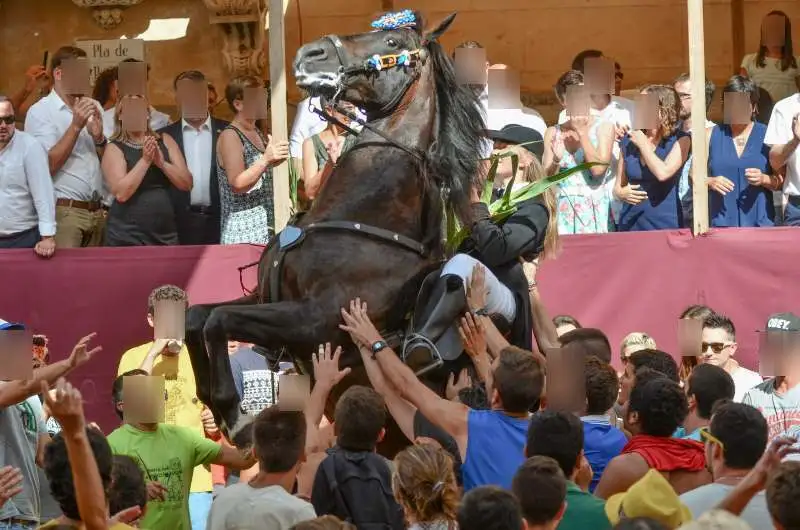 fiestas de Menorca en el jaleo donde aparece chica subida a un caballo realizando bailes y cabriolas rodeada de gente