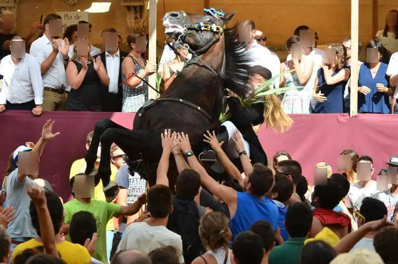 fiestas de Menorca en el jaleo donde aparece chica subida a un caballo realizando bailes y cabriolas rodeada de gente