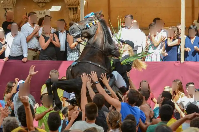 fiestas de Menorca en el jaleo donde aparece chica subida a un caballo realizando bailes y cabriolas rodeada de gente