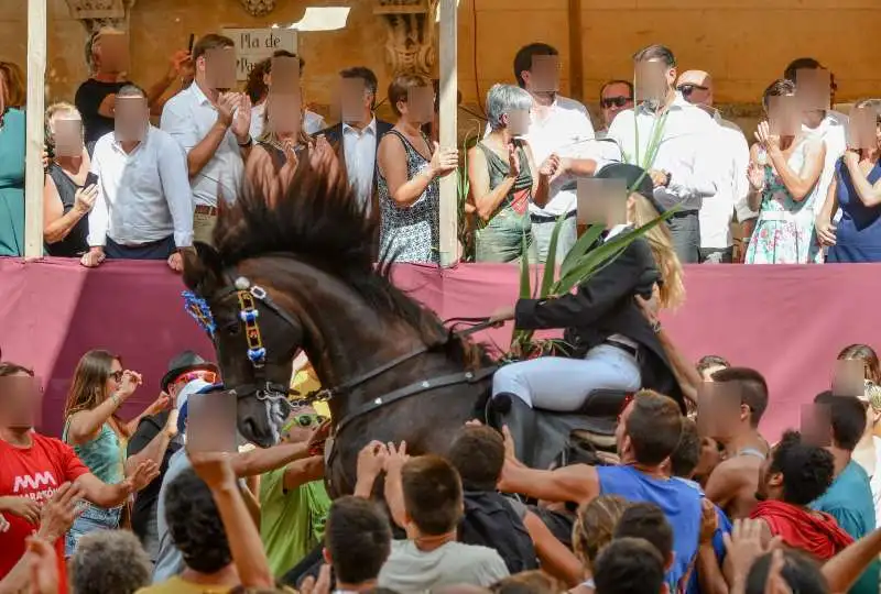 fiestas de Menorca en el jaleo donde aparece chica subida a un caballo realizando bailes y cabriolas rodeada de gente