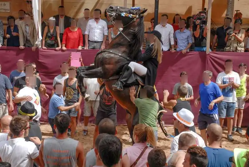 fiestas de Menorca en el jaleo donde aparece chica subida a un caballo realizando bailes y cabriolas rodeada de gente