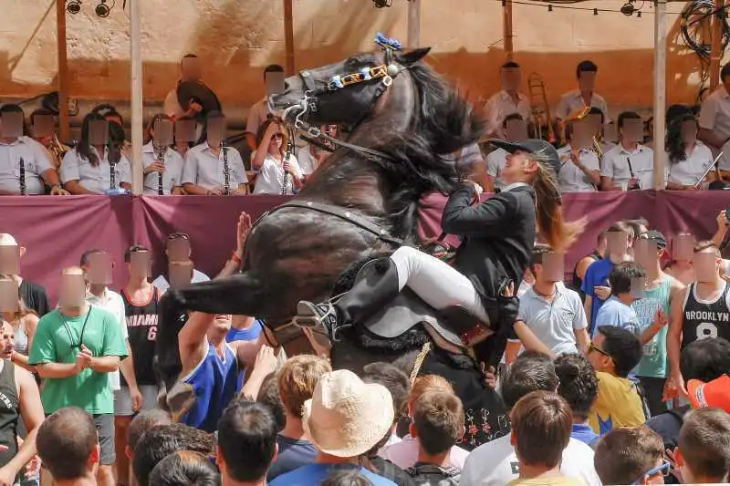 fiestas de Menorca en el jaleo donde aparece chica subida a un caballo realizando bailes y cabriolas rodeada de gente