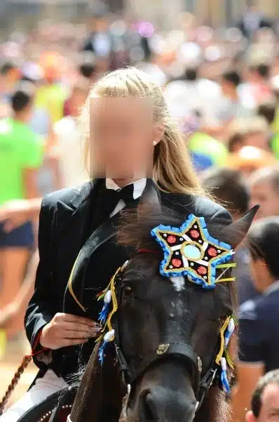 fiestas de Menorca en el jaleo donde aparece chica subida a un caballo realizando bailes y cabriolas rodeada de gente