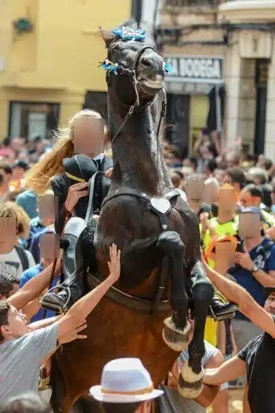 fiestas de Menorca en el jaleo donde aparece chica subida a un caballo realizando bailes y cabriolas rodeada de gente