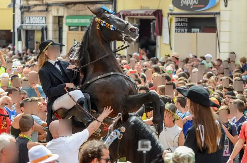 fiestas de Menorca en el jaleo donde aparece chica subida a un caballo realizando bailes y cabriolas rodeada de gente