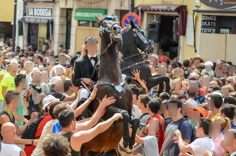 fiestas de Menorca en el jaleo donde aparece chica subida a un caballo realizando bailes y cabriolas rodeada de gente