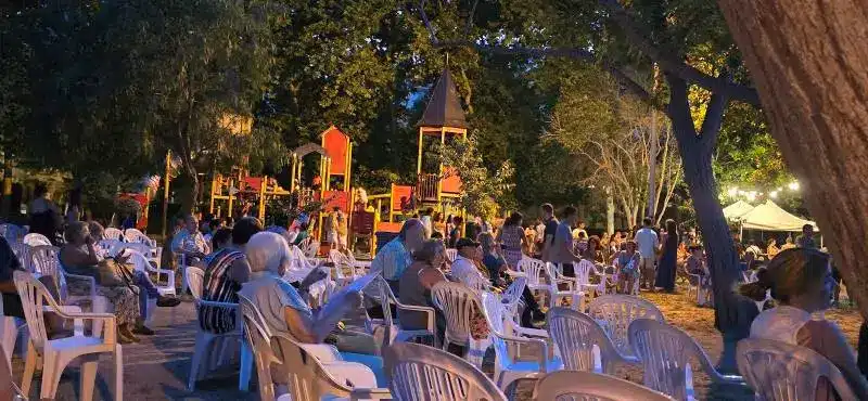 Grupo de personas sentadas viendo un concierto en las fiestas de Menorca