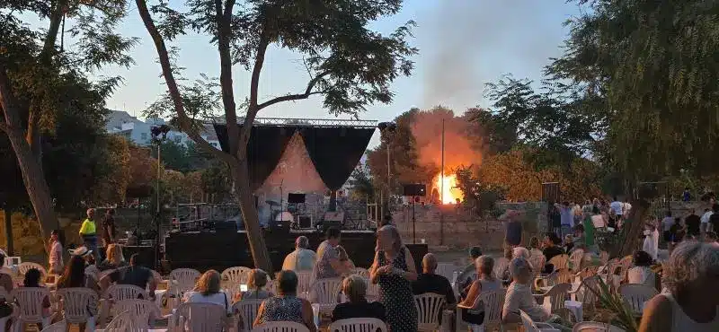 Grupo de personas sentadas viendo un concierto en las fiestas de Menorca