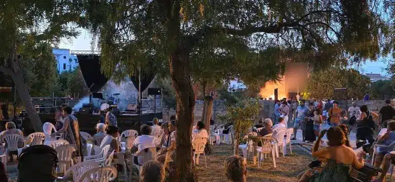 Grupo de personas sentadas viendo un concierto en las fiestas de Menorca