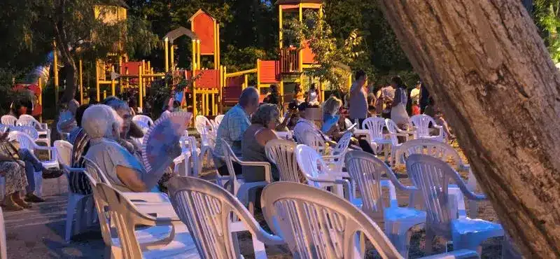 Grupo de personas sentadas viendo un concierto en las fiestas de Menorca