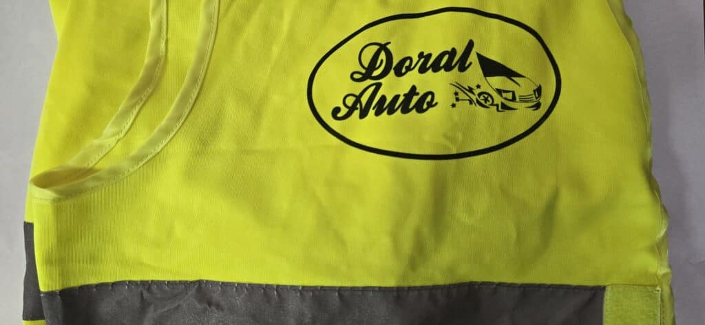 Chaleco reflectante amarillo con el logotipo de Doral Auto impreso en la parte frontal