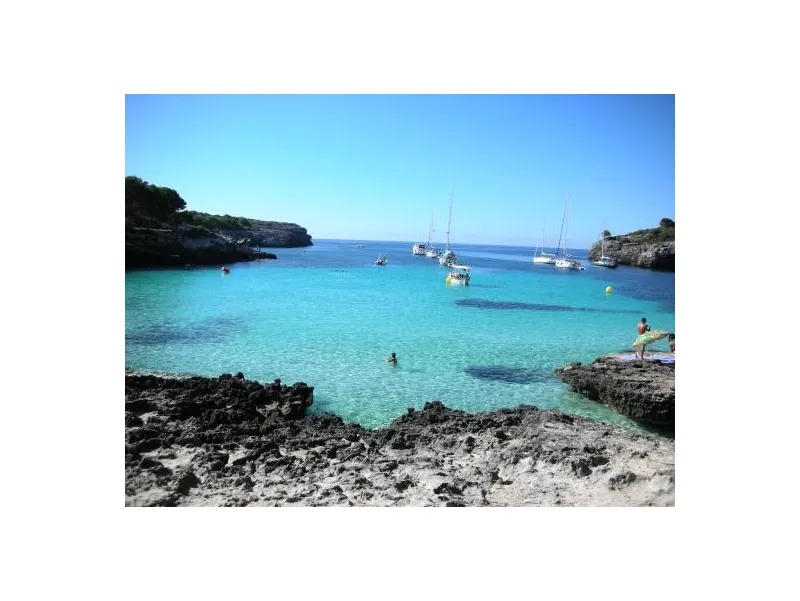 Cala Turqueta de Menorca y al fondo se ven barcos