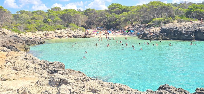 Vista Cala des Talaier en Menorca con gente bañandose