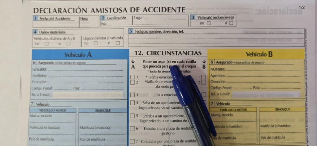 Formulario de declaración amistosa de accidente con bolígrafo azul sobre las casillas de circunstancias del parte amistoso