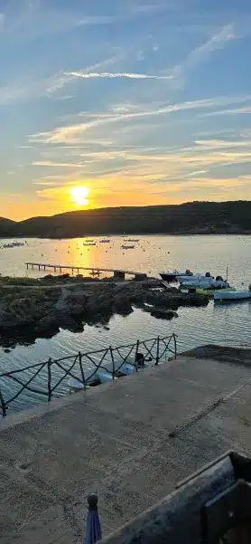 cala ES GRAU con pequeñas embarcaciones al fondo