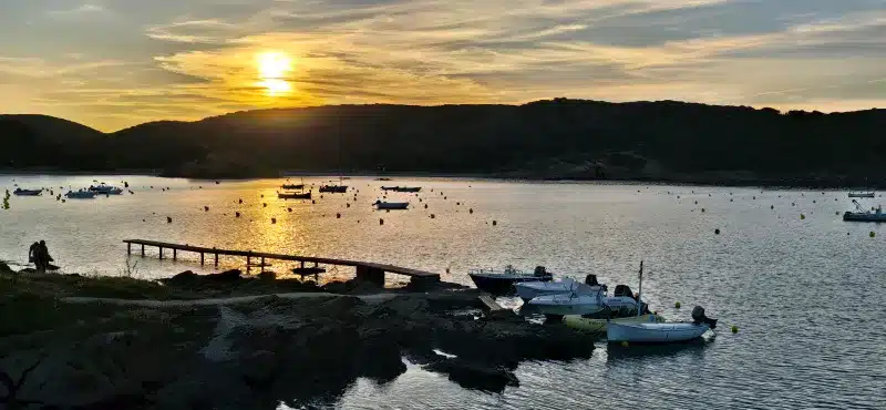 cala ES GRAU con pequeñas embarcaciones al fondo