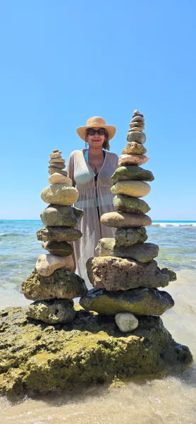 Mujer en la cala SON BOU delante de dos torres de piedras de mar