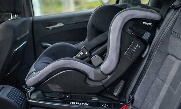 Silla de bebé ISOFIX instalada en el asiento trasero de un coche de alquiler en Menorca, lista para viajar seguro.