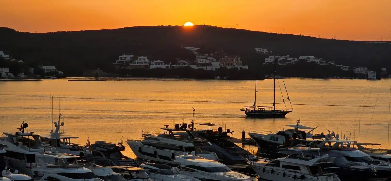 Puerto de Menorca al atardecer, destino ideal para explorar con un coche de alquiler en Menorca