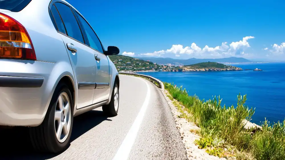 Coche recorriendo una carretera de costa en Menorca